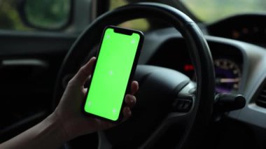 Arabada akıllı telefon yeşil ekran kullanan kişi