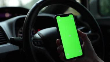 Arabada akıllı telefon yeşil ekran kullanan kişi