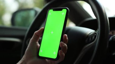 Arabada akıllı telefon yeşil ekran kullanan kişi