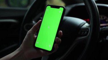 Arabada akıllı telefon yeşil ekran kullanan kişi