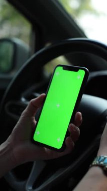 Arabada akıllı telefon yeşil ekran kullanan kişi