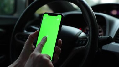 Arabada akıllı telefon yeşil ekran kullanan kişi