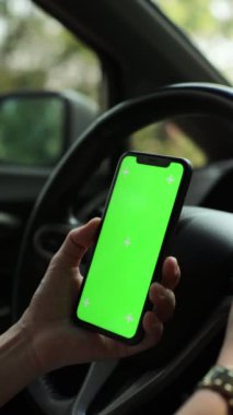 Arabada akıllı telefon yeşil ekran kullanan kişi