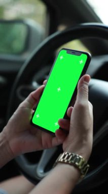 Arabada akıllı telefon yeşil ekran kullanan kişi