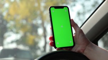Arabada akıllı telefon yeşil ekran kullanan kişi