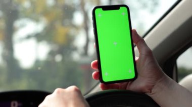 Arabada akıllı telefon yeşil ekran kullanan kişi