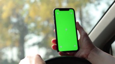Arabada akıllı telefon yeşil ekran kullanan kişi
