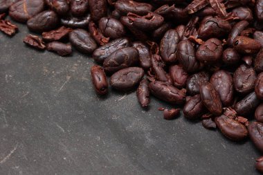 Kahverengi kavrulmuş kakao çekirdeği, siyah arka planda. 