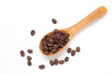 Kahverengi kahve çekirdekleri beyaz arka planda kaşık içinde. 