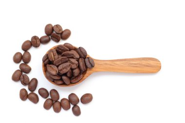 Beyaz zemin üzerine kaşık kahve çekirdekleri 