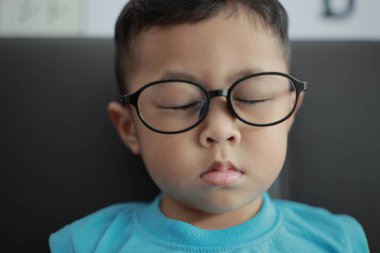 Çocuk kanepede oyun oynuyor, çocuklar telefon kullanıyor. 