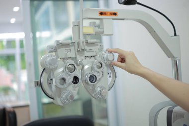 Doktorun elleri tıbbi aletleri çalıştırıyor. Doktorun eli hastanın görme yeteneğini ölçmek için bir makine kullanıyor..