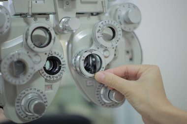 Doktorun elleri tıbbi aletleri çalıştırıyor. Doktorun eli hastanın görme yeteneğini ölçmek için bir makine kullanıyor..