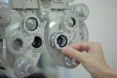 Doktorun elleri tıbbi aletleri çalıştırıyor. Doktorun eli hastanın görme yeteneğini ölçmek için bir makine kullanıyor..