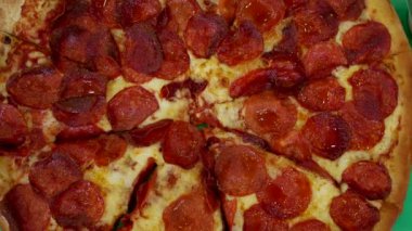 Pepperonili pizza dilimlerinin lezzeti elle tutulur. Lezzetli bir an yakaladık. Arzuları tatmin etmek ve aşçılık içeriği yaratmak için mükemmel.