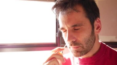 40 'lı yaşlarda İspanyol, siyah saçlı, kırmızı kazaklı, COVID testi yaptırıyor. Ön plan çubuk sokma ve döndürme görüntülerini yakalar. Çok yönlü kullanım için sol tarafında fotokopi alanı olan kalın görseller. Sorumlu sağlık uygulamaları