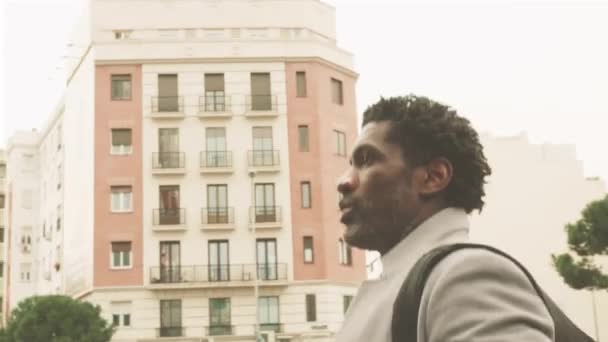 Zarif Siyahi Adamı Bölgesinin Sokaklarında Gri Paltolu Bir Gezgin Yürüyor — Stok video