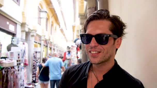 셔츠와 선글라스에 잘생긴 그라나다 시장에서 표지판 카메라 — 비디오