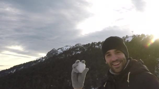 Hareket Etmeden Kameraya Kartopu Atıyor Yaşlardaki Gülümseyen Şapkalı Eldivenli Adam — Stok video