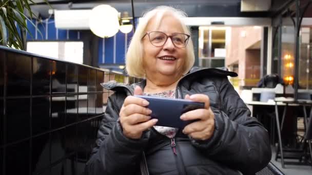 Блондинка Геймер Бабуся Окулярах Грає Смартфоні Кафе Втрачає Гру Сміється — стокове відео