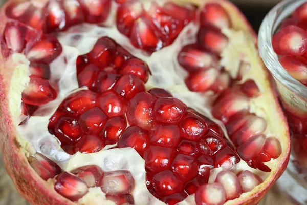 Open section of a pomegranate fruit exposing the ripe red seeds within. Healthful natural fruits for cancer patient