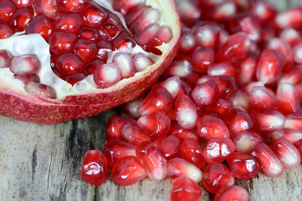 Open section of a pomegranate fruit exposing the ripe red seeds within. Healthful natural fruits for cancer patient