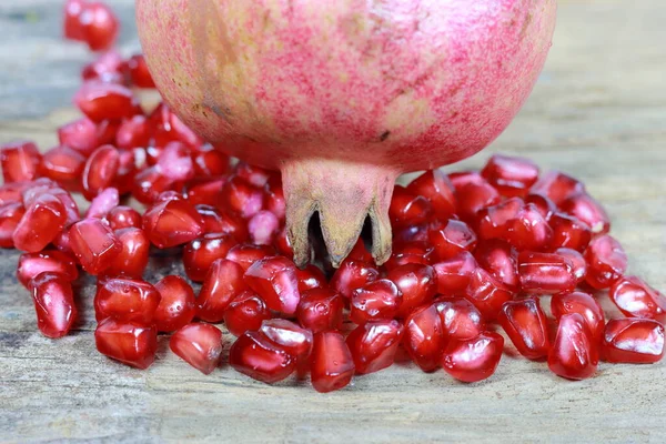 Red Pomegranate seeds on the wooden background. Fresh pomegranate close up picture on the wooden background. Healthful natural fruits for cancer patient