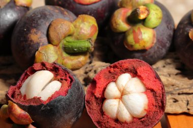 Lezzetli çekirdekli olgun mangosteen meyvesi seti. Meyve koyu mor veya kırmızıdır. Mor mangosteen olarak bilinir. Ahşap arka planda Mangosteen. Kanser önleme meyveleri. Sarsinya mangostana