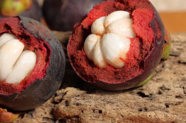 Lezzetli çekirdekli olgun mangosteen meyvesi seti. Meyve koyu mor veya kırmızıdır. Mor mangosteen olarak bilinir. Ahşap arka planda Mangosteen. Kanser önleme meyveleri. Sarsinya mangostana