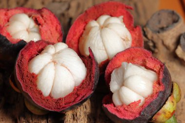 Lezzetli çekirdekli olgun mangosteen meyvesi seti. Meyve koyu mor veya kırmızıdır. Mor mangosteen olarak bilinir. Ahşap arka planda Mangosteen. Kanser önleme meyveleri. Sarsinya mangostana