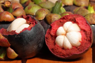 Ahşap arka planda Mangosteen. Kanser önleme meyveleri. Sulu çekirdekli mor mangosteen meyvesi.