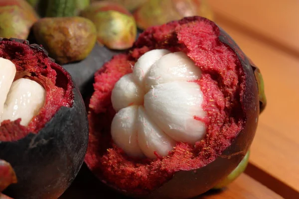 Ahşap arka planda Mangosteen. Kanser önleme meyveleri. Sulu çekirdekli mor mangosteen meyvesi.