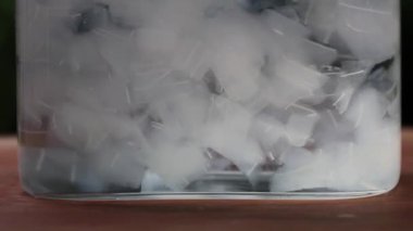 Su şişesinin içinde yüzen aloe vera kesikleri. Suyun içine aloe vera sıçratmanın yavaş hareketi