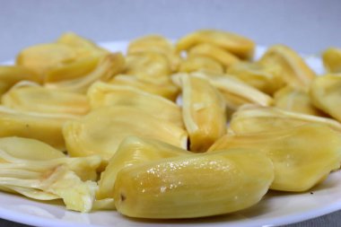Beyaz arka planda Jackfruit. Taze olgun meyveler. Taze, tatlı, meyveli, yenmeye hazır. Jackfruit kesiyorum. Tropik meyve. Seçici odak. 