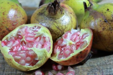 Nar meyvesinin açık bir bölümü içindeki olgun kırmızı tohumları ortaya çıkarıyor. Kanser hastaları için sağlıklı doğal meyveler