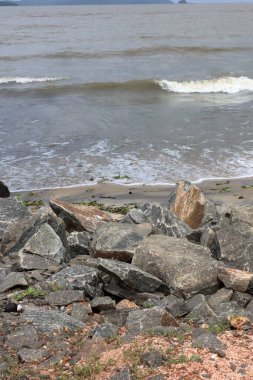 Dalgalar sahildeki kayalara çarpıyor. Kayalıkların oluşturduğu deniz dalgaları ve kabarcıklar.