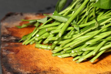 water spinach isolated on wooden background clipart