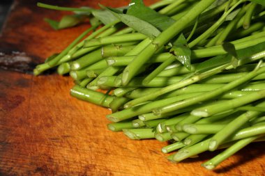 water spinach isolated on wooden background clipart