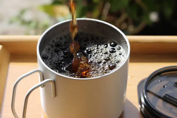 Çay, cam çay bardağına dökülüyor. Bardağa siyah çay dolduruyorum. Taze bitkisel çay. Sağlıklı bir sabah içkisi..