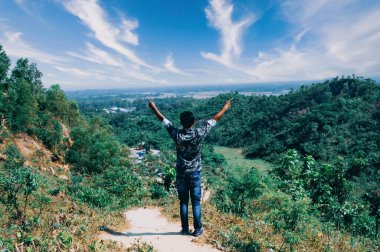 Güzel dağlar, ağaçlar, tepenin üstünde duran ve eğlenen bir adam.
