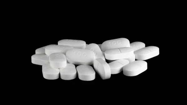 Siyah arka planda Sertraline 100 mg hapları. Setraline depresyon ve anksiyete bozuklukları için tedavi gören bir SSRI ya da antidepresandır.