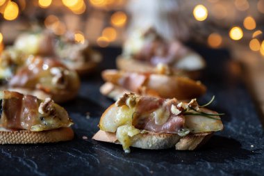 Noel kanepeleri armut, mavi peynir ve parma jambonundan yapılır.