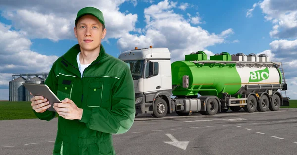 Man with digital tablet on a background of truck with a tank with the inscription BIO