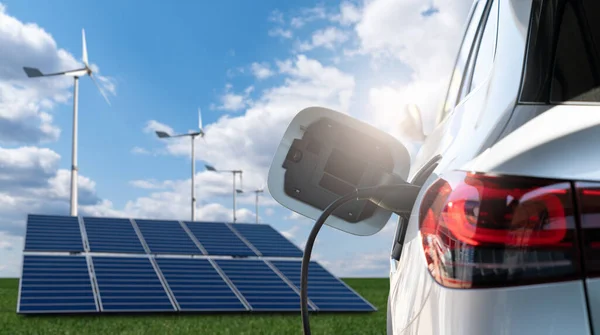 太陽光パネルと風力タービンの背景に接続充電ケーブルを備えた電気自動車の閉鎖 — ストック写真