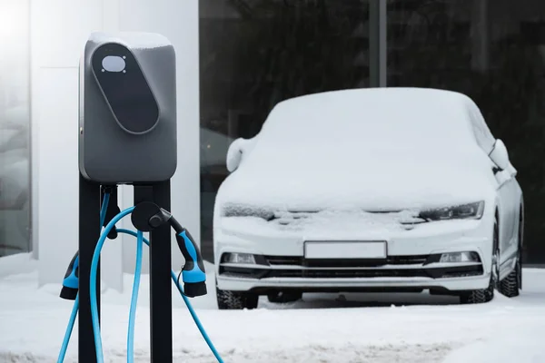 Σταθμός Φόρτισης Ηλεκτρικών Αυτοκινήτων Φόντο Χειμερινών Αυτοκινήτων Καλυμμένων Χιόνι — Φωτογραφία Αρχείου