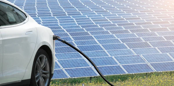 Detailní Záběr Elektromobilu Připojeným Nabíjecím Kabelem Pozadí Solárních Panelů — Stock fotografie