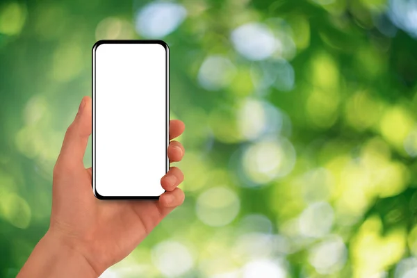 Hand with smartphone on a green background