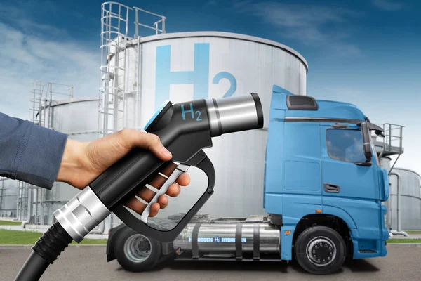 Hand with H2 fueling nozzle on a background of hydrogen fuel cell semi truck