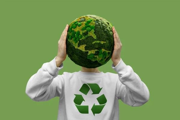 Woman holding a green planet Earth with recycling symbol
