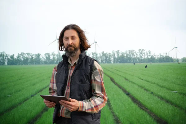 Farmer with digital tablet on an agricultural field. Smart farming and digital agriculture